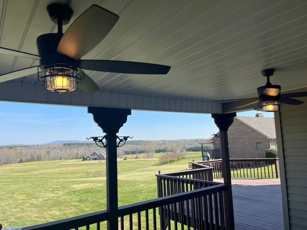 Outdoor ceiling fans with lights installed on a covered porch